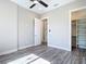 Bedroom featuring wood-look floors, a ceiling fan, a closet and multiple doorways at 7152 Bougainvillea St, Englewood, FL 34224