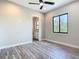 Bedroom with wood-look floors, a ceiling fan, and a bathroom view through an open door at 7152 Bougainvillea St, Englewood, FL 34224
