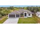 Eye-level exterior showcasing this home's three-car garage, brick driveway, and a well-maintained front lawn at 7152 Bougainvillea St, Englewood, FL 34224