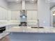 Modern kitchen with white cabinets, stainless steel appliances, and a breakfast bar with granite countertops at 7152 Bougainvillea St, Englewood, FL 34224