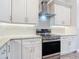 Bright kitchen featuring white cabinets, granite countertops, tile backsplash, and stainless steel appliances at 7152 Bougainvillea St, Englewood, FL 34224