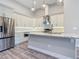New kitchen with stainless steel appliances, a breakfast bar, and white shaker style cabinets at 7152 Bougainvillea St, Englewood, FL 34224