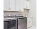 Well-lit laundry room featuring modern washer and dryer, granite countertop, and white cabinetry at 7152 Bougainvillea St, Englewood, FL 34224