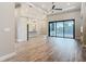 Spacious living room with wood flooring and a sliding glass door with a view of the pool at 7152 Bougainvillea St, Englewood, FL 34224