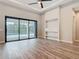 This open living area has wood floors, a ceiling fan, and sliding doors to a screened in pool at 7152 Bougainvillea St, Englewood, FL 34224