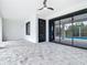 A spacious covered patio with patterned tile flooring and views of the screened-in pool area at 7152 Bougainvillea St, Englewood, FL 34224