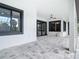 Wide, covered patio with stone tile floor, black trimmed doors and windows, and white walls at 7152 Bougainvillea St, Englewood, FL 34224