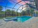 A large swimming pool and spa are enclosed in a screened in area with a beautiful dusk sky at 7152 Bougainvillea St, Englewood, FL 34224