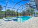 A large swimming pool and spa are enclosed in a screened in area with views of the backyard at 7152 Bougainvillea St, Englewood, FL 34224