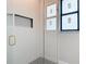 Modern shower showcasing herringbone tile, black framed window, and a convenient built-in niche at 7152 Bougainvillea St, Englewood, FL 34224