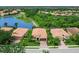 Aerial view of a residential property with a well-manicured lawn and landscaping near a lake at 8911 Heritage Sound Dr, Bradenton, FL 34212