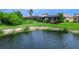 Scenic backyard with lush green lawn, pond, and mature trees at 8911 Heritage Sound Dr, Bradenton, FL 34212