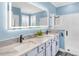 Modern bathroom featuring dual vanities, a large mirror, and a walk-in shower with sleek fixtures at 8911 Heritage Sound Dr, Bradenton, FL 34212