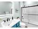 This stylish bathroom includes a blue vanity and a modern tub-shower combo with glass doors at 8911 Heritage Sound Dr, Bradenton, FL 34212