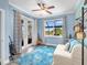 Inviting bedroom with a coastal theme, comfortable chair, and views of the outdoors through a large window at 8911 Heritage Sound Dr, Bradenton, FL 34212