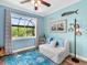 Relaxing bedroom with blue accents, comfortable seating, and a large window overlooking the screened lanai at 8911 Heritage Sound Dr, Bradenton, FL 34212