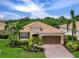 Charming one-story home with tile roof, well-manicured lawn, brick paved driveway, and lush tropical landscaping at 8911 Heritage Sound Dr, Bradenton, FL 34212