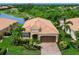 Beautiful one-story home with lush landscaping, tile roof, and brick paved driveway overlooking a pond at 8911 Heritage Sound Dr, Bradenton, FL 34212