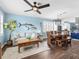 Bright living room featuring modern coastal decor, ceiling fan, and seamless flow into dining area and kitchen at 8911 Heritage Sound Dr, Bradenton, FL 34212