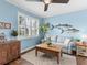 Cozy living room boasts natural light from plantation shutters, complemented by hardwood floors and stylish decor at 8911 Heritage Sound Dr, Bradenton, FL 34212