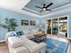 Bright living room featuring a white sectional, blue accents, and sliding glass doors to the lanai at 8911 Heritage Sound Dr, Bradenton, FL 34212