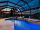 Gorgeous pool with beautiful waterfall, colorful lights, screened enclosure and water view at 8911 Heritage Sound Dr, Bradenton, FL 34212