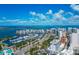 Dramatic aerial of Sarasota featuring waterfront condos, marina with boats, and a connecting bridge against a backdrop of blue sky at 101 S Gulfstream Ave # 16C, Sarasota, FL 34236