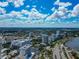 Scenic aerial view featuring Sarasota's high-rise buildings, lush greenery, roads, and the bay, all beneath a beautiful cloudscape at 101 S Gulfstream Ave # 16C, Sarasota, FL 34236