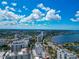 Sprawling aerial view of a city, revealing modern architecture, lush landscapes, and serene waters under a partly cloudy blue sky at 101 S Gulfstream Ave # 16C, Sarasota, FL 34236