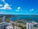 Striking aerial view capturing the expansive bay, marina, and buildings of a coastal city under a beautiful sky with fluffy clouds at 101 S Gulfstream Ave # 16C, Sarasota, FL 34236