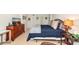 This is a bedroom featuring tile floors, a comfortable bed with a blue quilt, and a wooden dresser at 101 S Gulfstream Ave # 16C, Sarasota, FL 34236