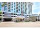 A white, high-rise building has multiple balconies and covered parking, with an American flag visible at 101 S Gulfstream Ave # 16C, Sarasota, FL 34236