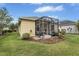Home's backyard featuring a screened lanai, a grill and a manicured lawn at 11835 Crawford Parrish Ln, Parrish, FL 34219