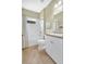 Bright bathroom with a shower-tub combo, white vanity, decorative art and neutral tile floors at 11835 Crawford Parrish Ln, Parrish, FL 34219
