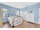 Bright bedroom with wood floors, blue walls, walk-in closet, and en suite bathroom at 11835 Crawford Parrish Ln, Parrish, FL 34219