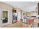 Open kitchen features stainless steel appliances, tile floors, and a seamless flow to the living area at 11835 Crawford Parrish Ln, Parrish, FL 34219