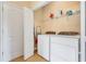 Functional laundry room with side-by-side washer and dryer units, utility closet, and storage at 11835 Crawford Parrish Ln, Parrish, FL 34219