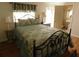 Bedroom with iron bed frame, lamps, and wood flooring at 1212 45Th E Ave, Ellenton, FL 34222