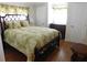 Bright bedroom with tropical bedding, dark wood frame bed, and wood-look floors at 1212 45Th E Ave, Ellenton, FL 34222