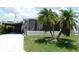 Charming manufactured home with a screened-in lanai, covered parking, and lush tropical landscaping at 1212 45Th E Ave, Ellenton, FL 34222