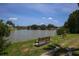 Scenic lake view with benches, lush green lawn, and blue sky, a perfect spot for relaxation at 1212 45Th E Ave, Ellenton, FL 34222