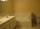 Bathroom featuring a tiled tub, white cabinets, tile floors, and a toilet at 12301 Mosswood Pl, Lakewood Ranch, FL 34202