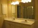 Bathroom featuring double sinks with white cabinetry and a large mirror at 12301 Mosswood Pl, Lakewood Ranch, FL 34202