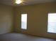 Bedroom with neutral walls, carpet, ceiling fan and bright natural light from two windows at 12301 Mosswood Pl, Lakewood Ranch, FL 34202