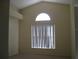Bright bedroom with neutral carpet, tall ceilings and a large arched window at 12301 Mosswood Pl, Lakewood Ranch, FL 34202