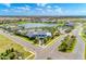 Wide aerial view of community with lake, clubhouse, pool, and surrounding landscape at 13918 Old Creek Ct, Parrish, FL 34219
