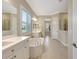 Bright bathroom featuring a soaking tub, double vanity, neutral tones, and modern fixtures at 13918 Old Creek Ct, Parrish, FL 34219