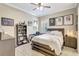 Well-lit bedroom with wood-look flooring, fan, desk, and personal touches at 13918 Old Creek Ct, Parrish, FL 34219