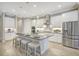 Modern kitchen featuring white cabinetry, stainless steel appliances, a large island with seating, and pendant lighting at 13918 Old Creek Ct, Parrish, FL 34219