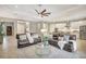 Open-concept living room featuring modern furnishings, a ceiling fan, and seamless flow to a white kitchen at 13918 Old Creek Ct, Parrish, FL 34219